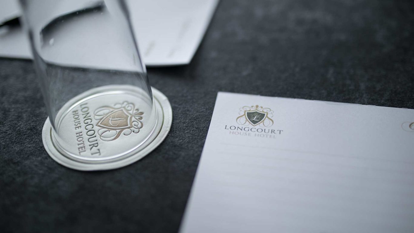 Elegant Longcourt House Hotel stationery and glass set on a stylish table, embodying luxury and sophistication.
